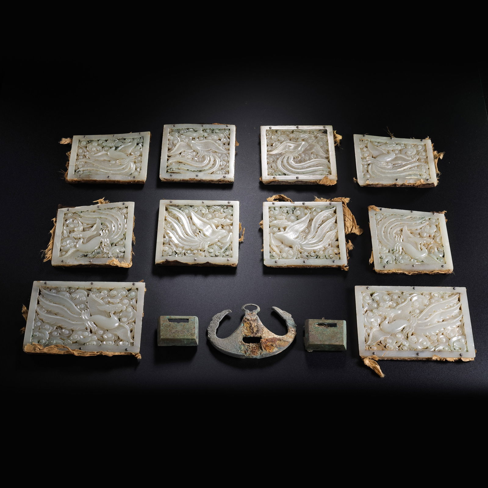 A RARE AND MAGNIFICENT SET OF TEN JADE-INLAID COPPER MOUNTS WITH OPENWORK 'PHOENIX' PLAQUESLIAO: Description The set comprises ten (10) substantial plaques of Khotan white jade, each masterfully carved in intricate multi-layered openwork (loukong). The central motif of each plaque features a maje