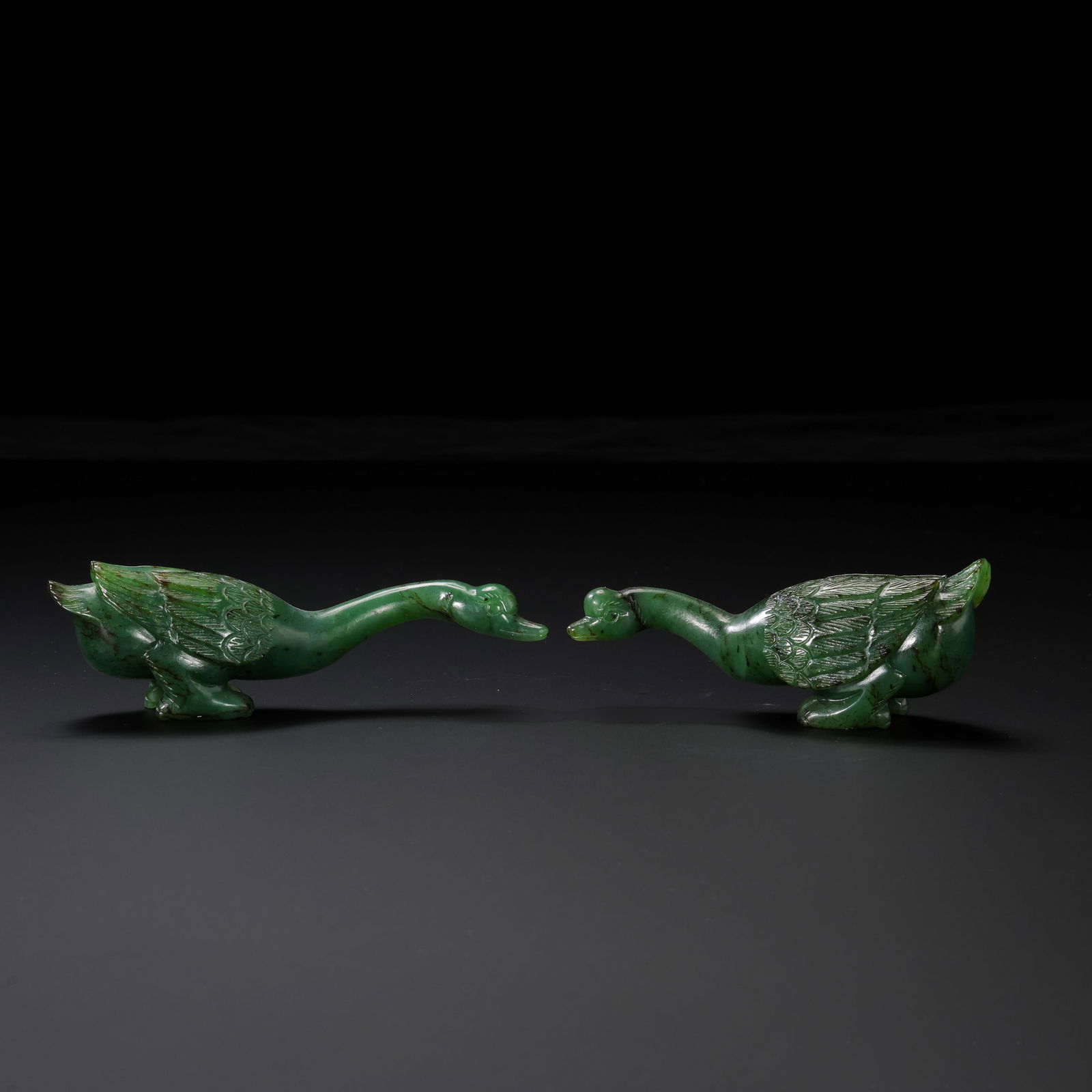RARE AND MAGNIFICENT PAIR OF SPINACH-GREEN JADE 'GOOSE' FIGURESQING DYNASTY, QIANLONG PERIOD: DescriptionThis exceptional pair of figures is masterfully carved from high-quality Hetian spinach-green jade (bi-yu). The stone exhibits a deep, vibrant forest-green hue, characteristic of the finest