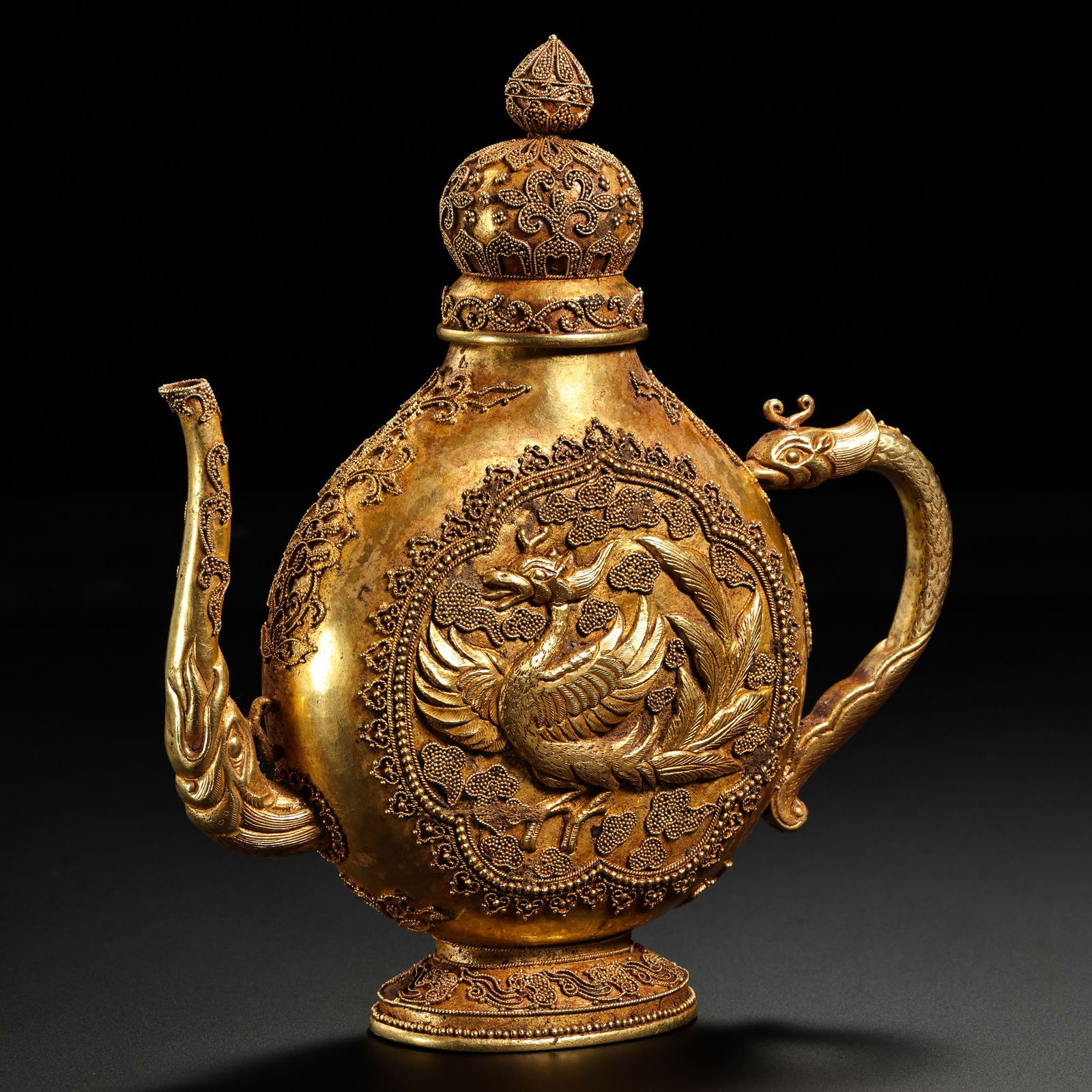 A MAGNIFICENT AND EXCEPTIONALLY RARE SOLID GOLD 'PHOENIX' EWERTANG DYNASTY (618–907 AD): Description This monumental gold ewer is a breathtaking testament to the opulence and cosmopolitan artistic fervor of the Tang Dynasty. The vessel features a flattened globular body (lentoid shape), s