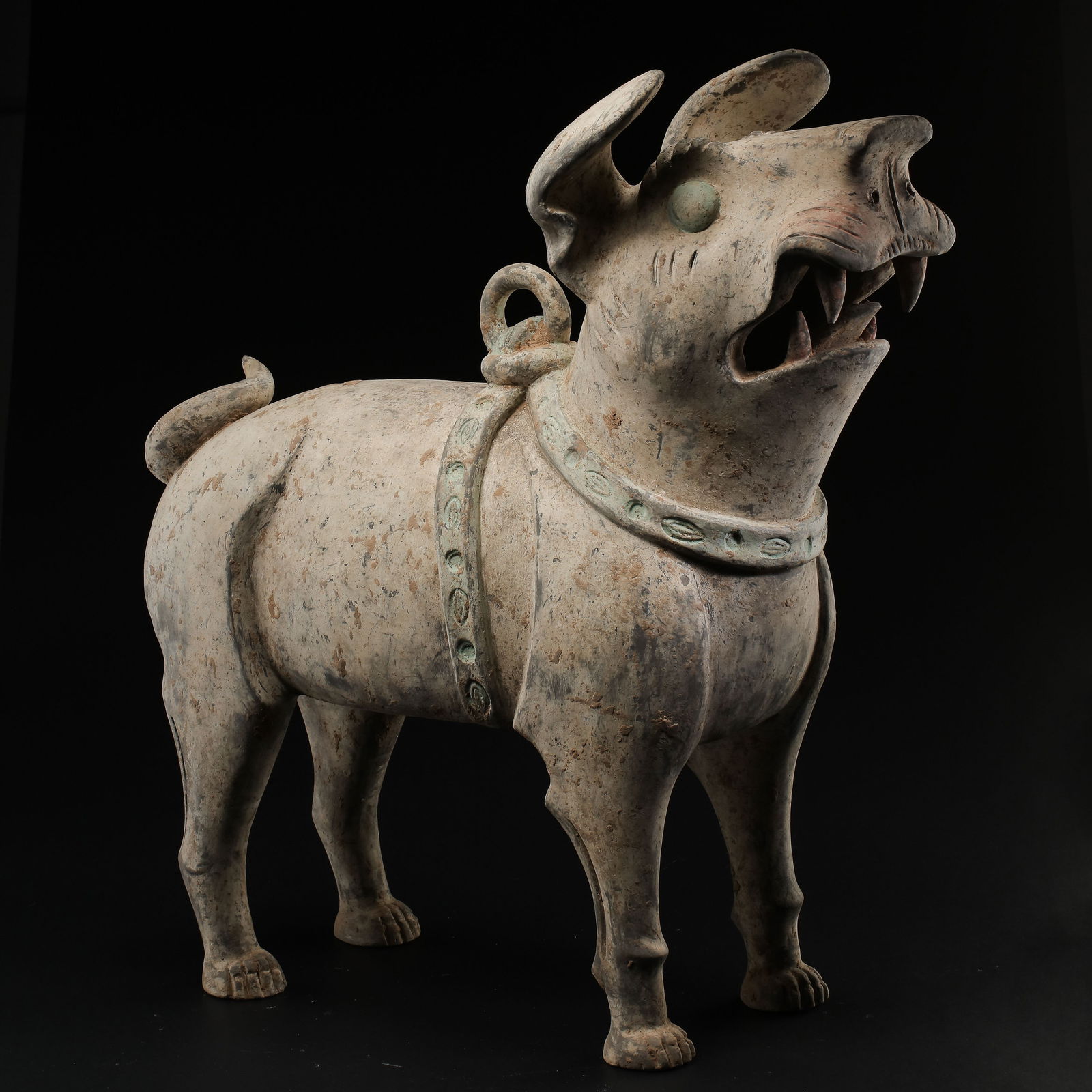 A RARE AND VIBRANTLY MODELED POTTERY FIGURE OF A SEATED HOUNDTANG DYNASTY (618–907): The figure is naturalistically modeled as a lean hound seated on its haunches upon a rectangular plinth. The dog is depicted with an alert expression, its head slightly tilted and ears pricked forward