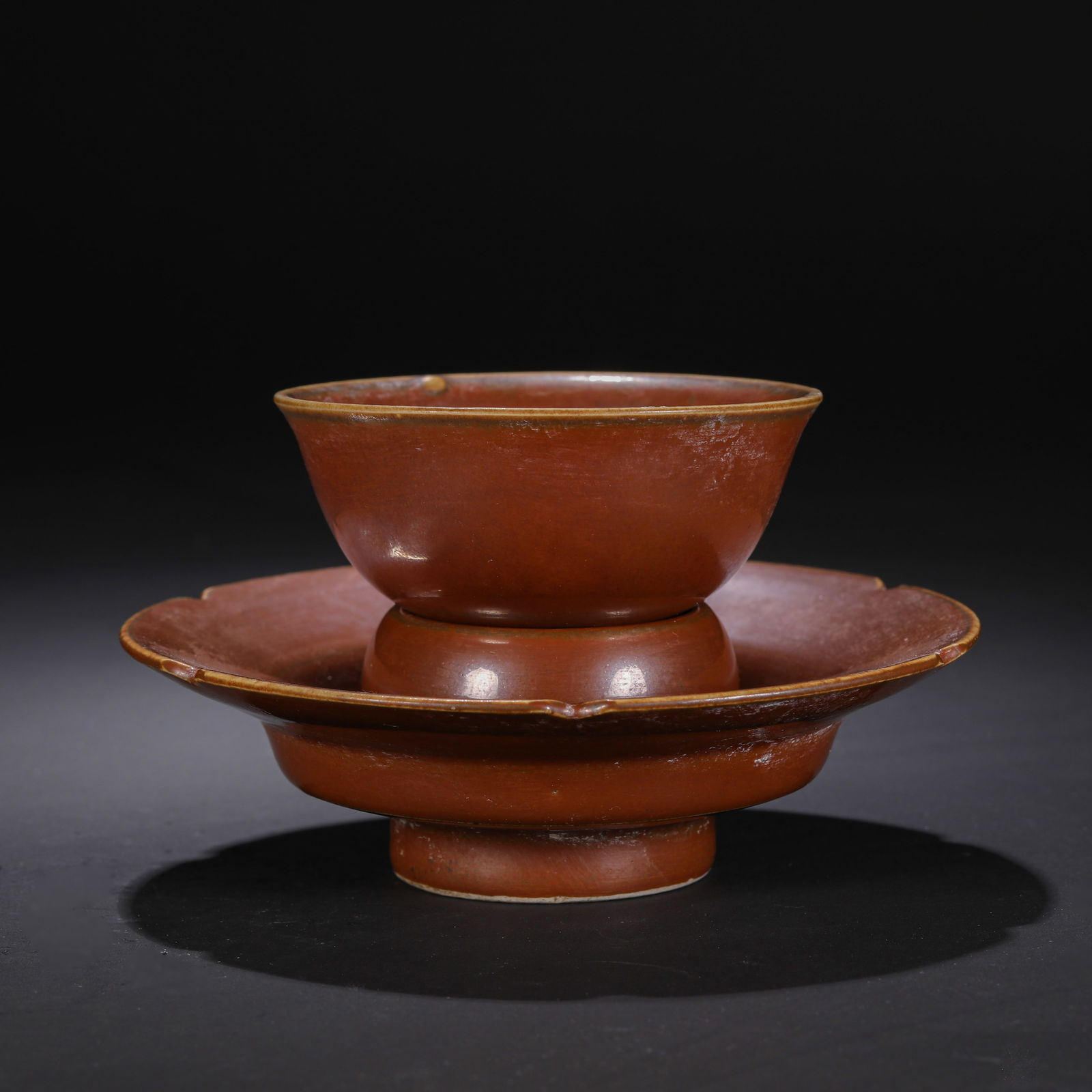 AN EXCEPTIONALLY RARE PERSIMMON-GLAZED CUP STANDNORTHERN SONG DYNASTY (960-1127): DescriptionThe cup stand is elegantly proportioned, featuring a circular, raised central pedestal with a hollow interior designed to support a tea bowl. The pedestal is set atop a broad, spreading dis
