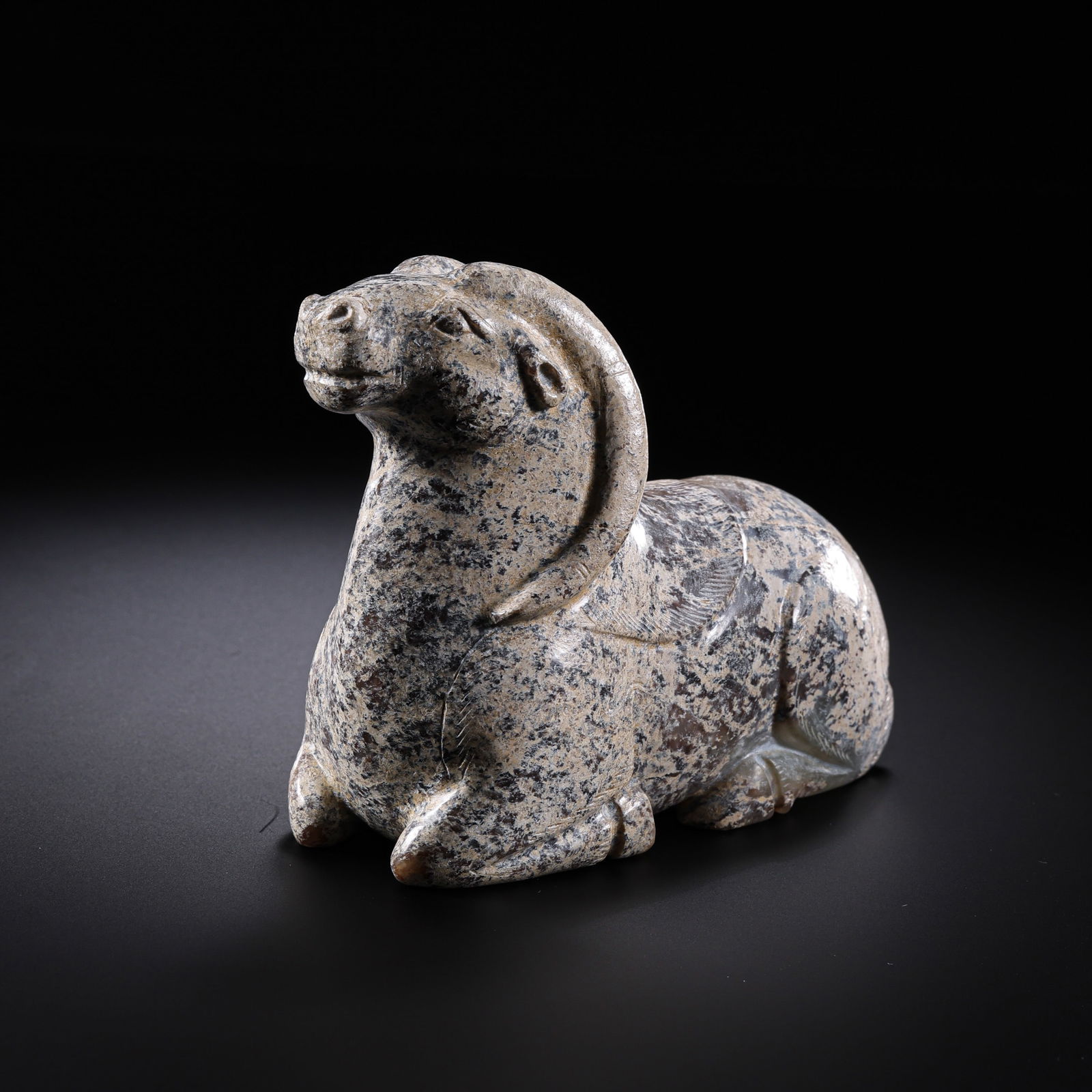 A RARE AND MAGNIFICENT HETIAN WHITE JADE RECUMBENT RAMWARRING STATES TO HAN DYNASTY (C. 4TH CENTURY: DescriptionThe ram is masterfully sculpted in the round from a single, exceptionally large and dense block of Hetian white jade. It is depicted in a peaceful recumbent position, with its legs tucked n