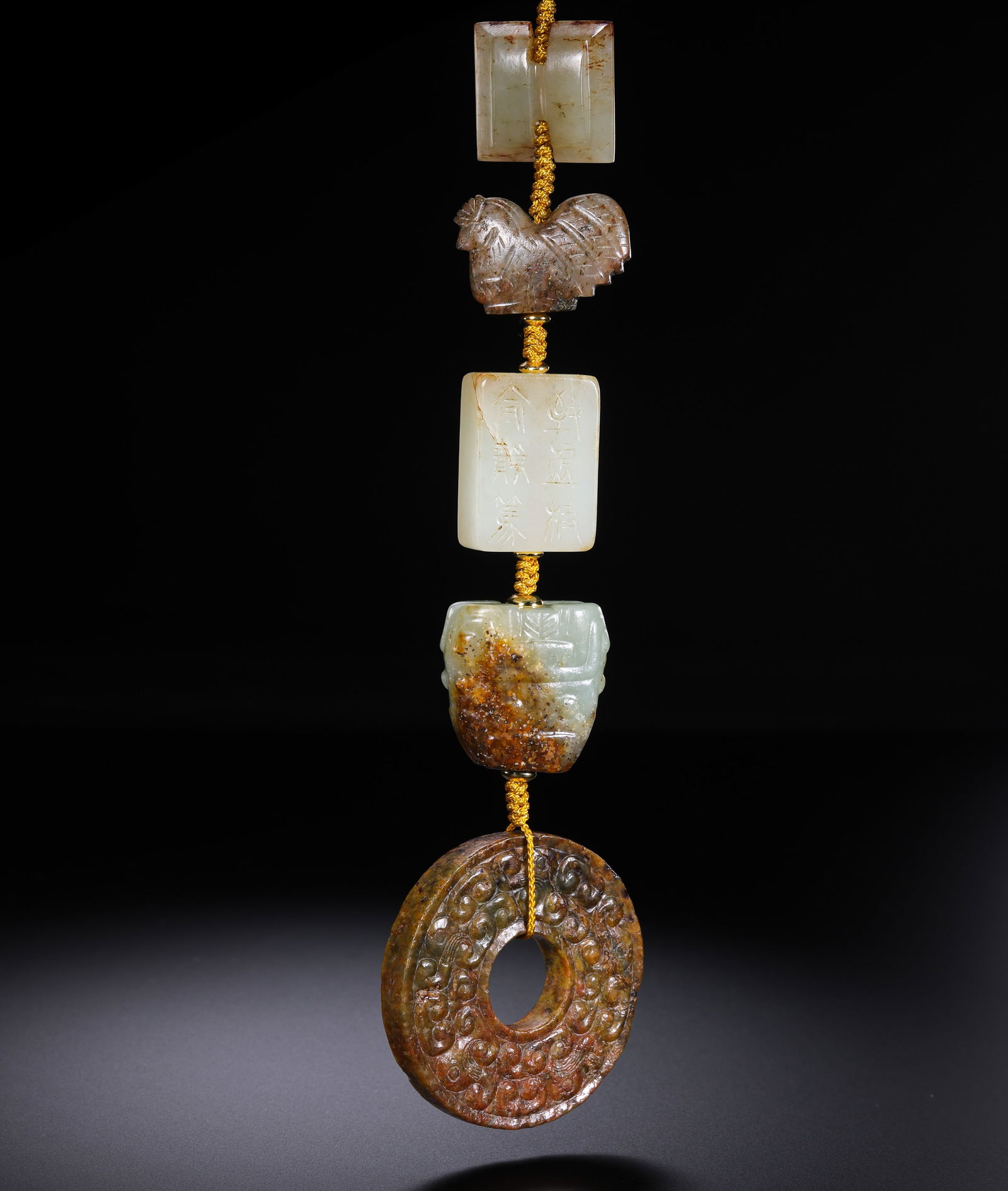 A RARE COMPOSITE SET OF FIVE JADE PENDANTS AND ORNAMENTSHAN DYNASTY STYLE AND POSSIBLY LATER (C. 2ND: Description This curated ensemble comprises five distinct jade elements, each masterfully carved from varieties of nephrite jade, ranging from pale celadon to unctuous white tones. The stone surfaces