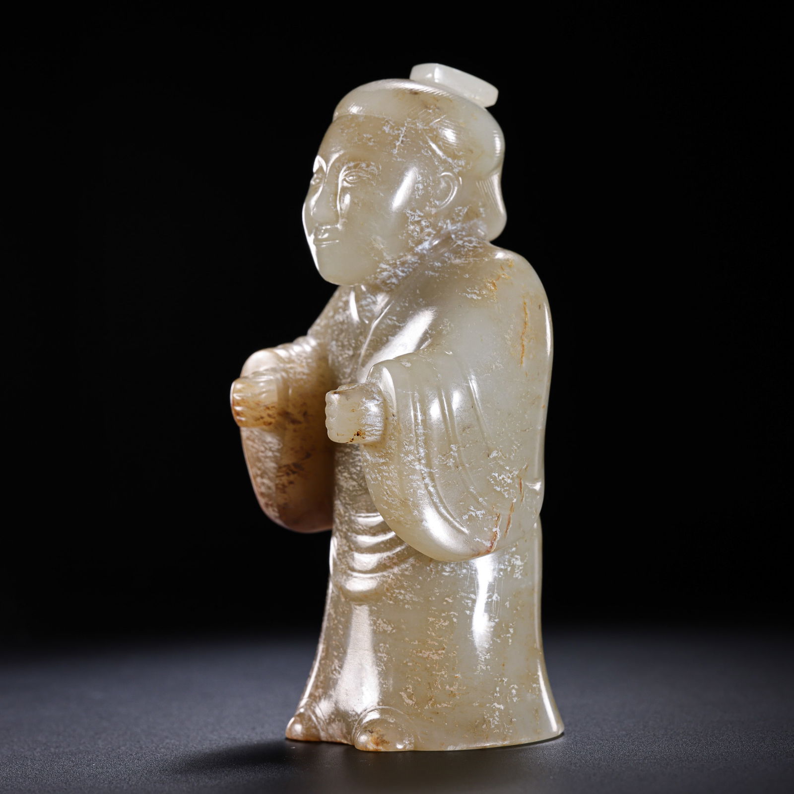 A RARE AND MAGNIFICENT HETIAN WHITE JADE STANDING FIGUREHAN DYNASTY (206 BC – 220 AD): Description The figure is masterfully sculpted in the round from a single, substantial block of Hetian white jade (nephrite). It depicts a dignified attendant or official in a formal standing position