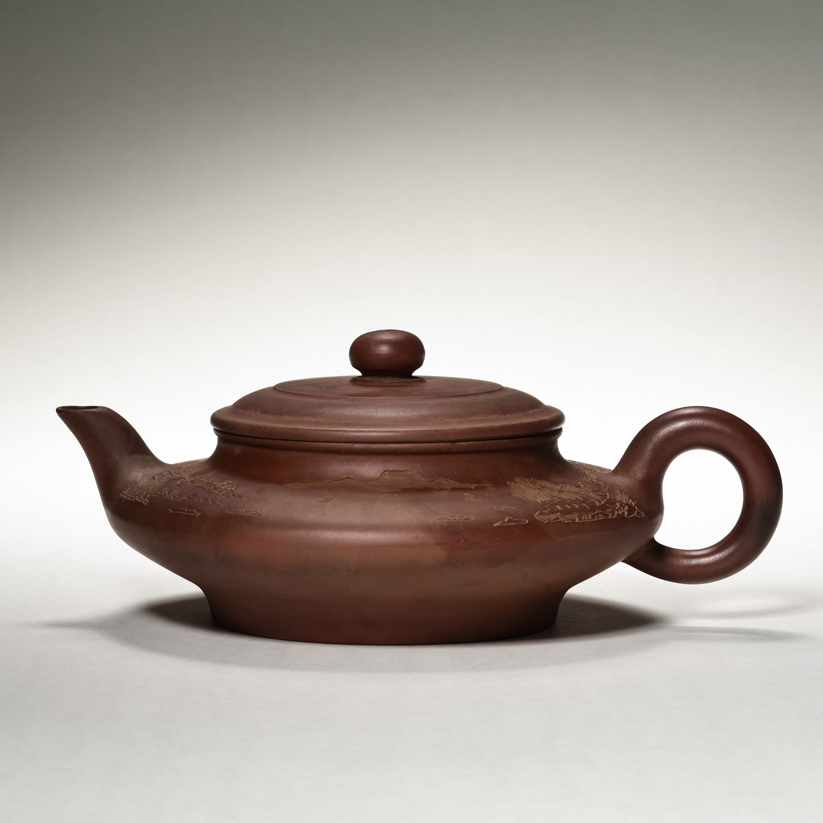 A RARE AND MAGNIFICENT ZISHA 'LANDSCAPE' TEAPOTBY GU JINGZHOU (1915–1996), MODERN PERIOD: Description This exquisitely preserved Zisha teapot is a testament to the mastery of Gu Jingzhou, the legendary "Grandmaster of Zisha." Crafted from premium, finely-levigated purple clay, the vessel e
