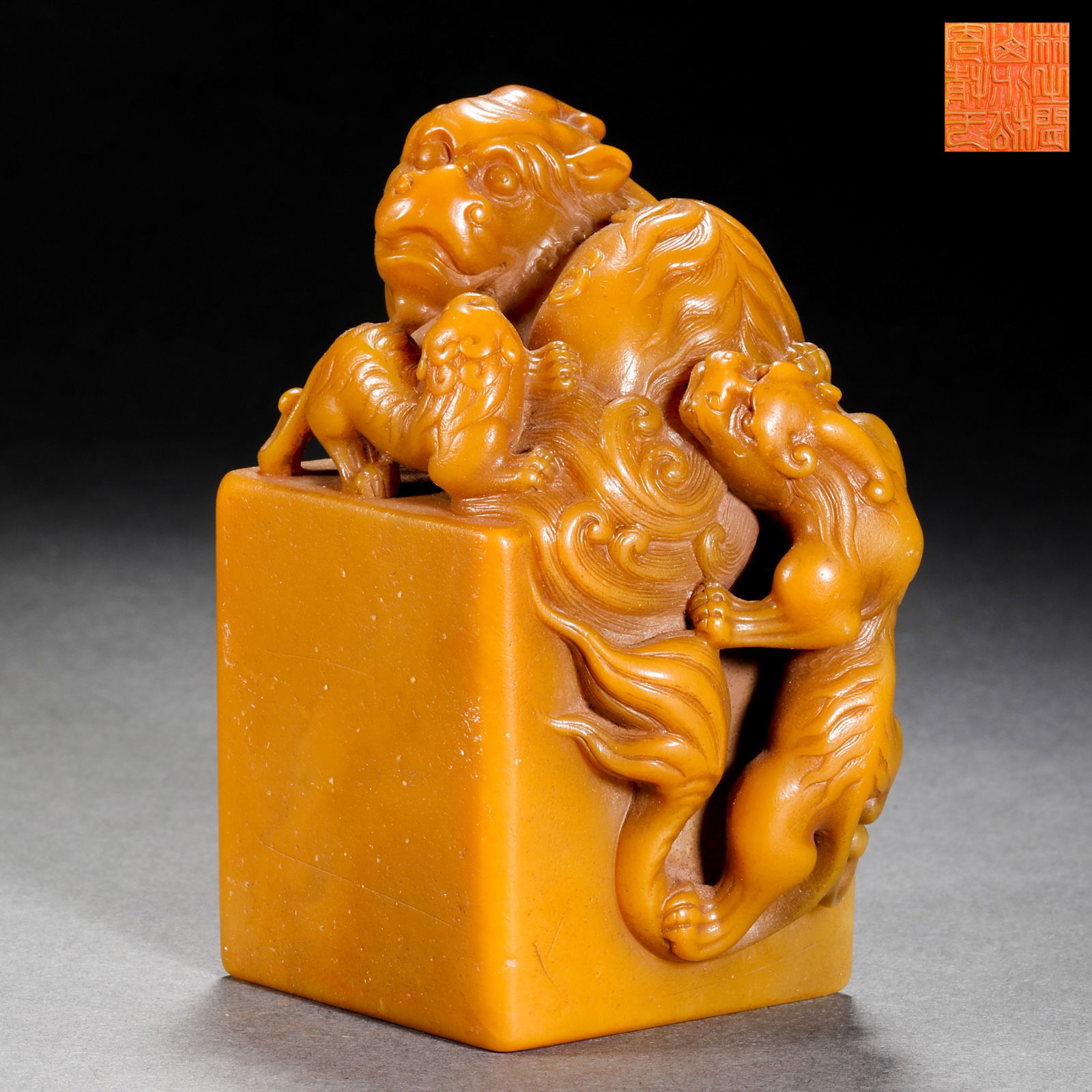 A MAGNIFICENT 'TIANHUANG' STONE 'LION-KNOB' SEALQING DYNASTY (18TH - 19TH CENTURY): The seal is masterfully carved from a high-quality block of 'field-yellow' (tianhuang) stone, displaying an intense golden-orange hue and a luminous, honey-like translucency . The seal is surmounted b