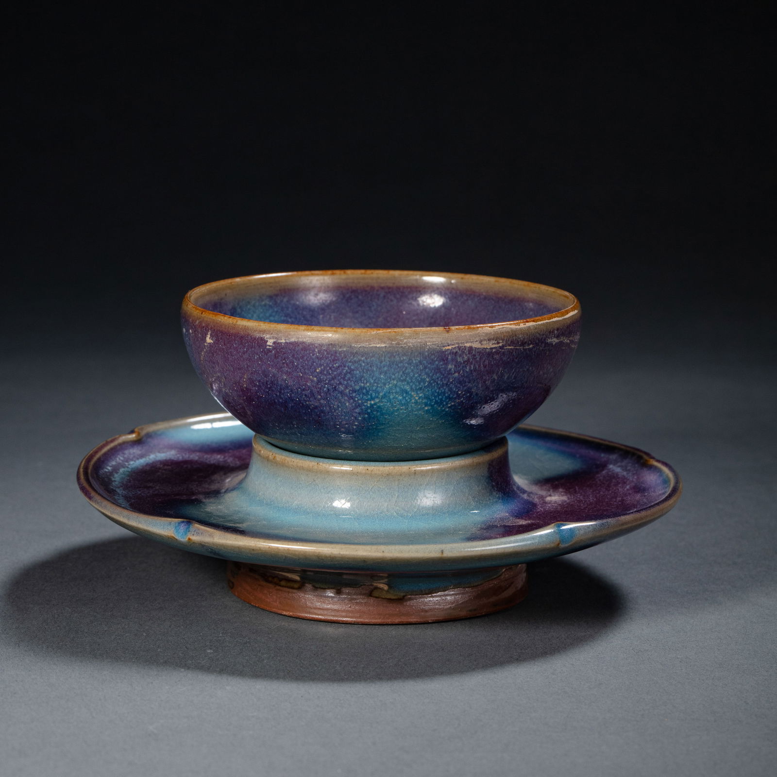 A RARE 'JUN' OPALESCENT SKY-BLUE GLAZED CUP STANDSONG – JIN DYNASTY (12TH – 13TH CENTURY): The cup stand is elegantly potted with a central raised circular platform designed to support a tea bowl, set within a wide, spreading saucer-shaped rim with a slightly upturned edge. The whole is sup