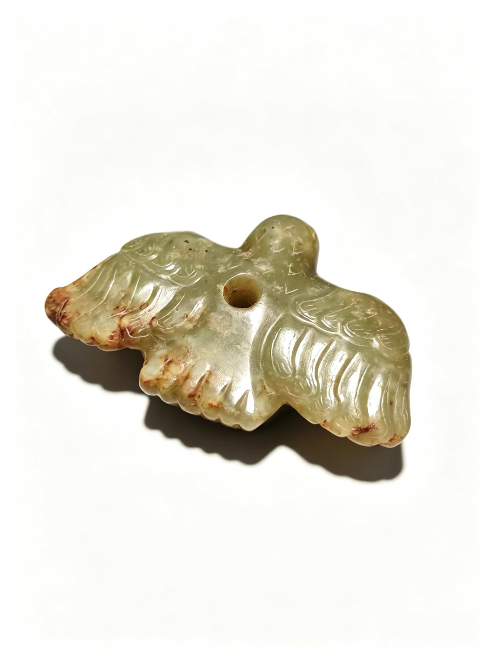 Celadon Jade Xuan Niao Pendant: Celadon Jade Xuan Niao PendantProposed Period: Warring States to Han DynastyMaterial: Hetian celadon jadeDimensions: Length 3.5 cm (1.38 in), Thickness 2 cm (0.79 in)Weight: Approximately 188 gramsFor