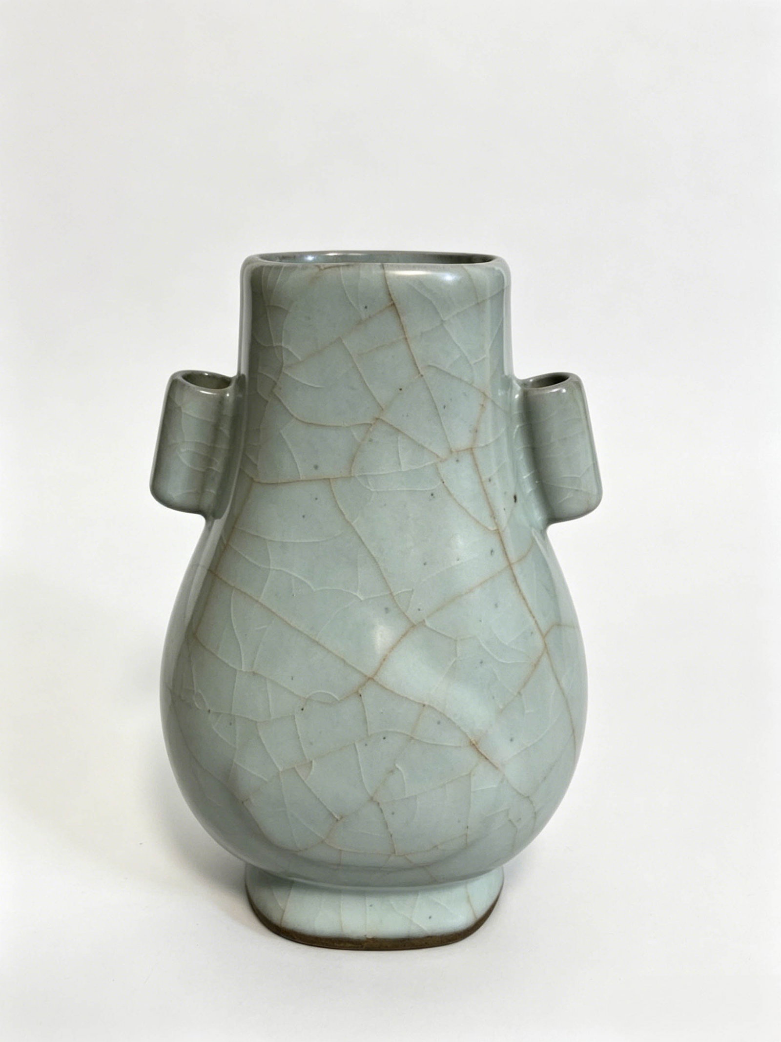 Celadon Crackled Guan?style Vase with Pierced Handles: Celadon Crackled Guan?style Vase with Pierced HandlesSuggested Date: Qing Dynasty, in imitation of Song Guan?ware styleDimensions: Height 7.09 inches, belly diameter 4.53 inchesCondition: No body