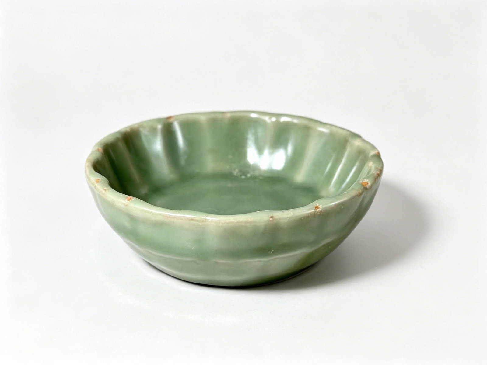 Yuan Dynasty Longquan Kiln Plum-Green Sugarcane-Segment Floral-Rim Brush Washer: Basic InformationPeriod: Yuan DynastyKiln: Longquan Kiln (Core Dayao Kiln Site)Vessel Form: Sugarcane-segment floral-rim washer, triple-purpose as scholar’s brush rest, incense dish and decorative