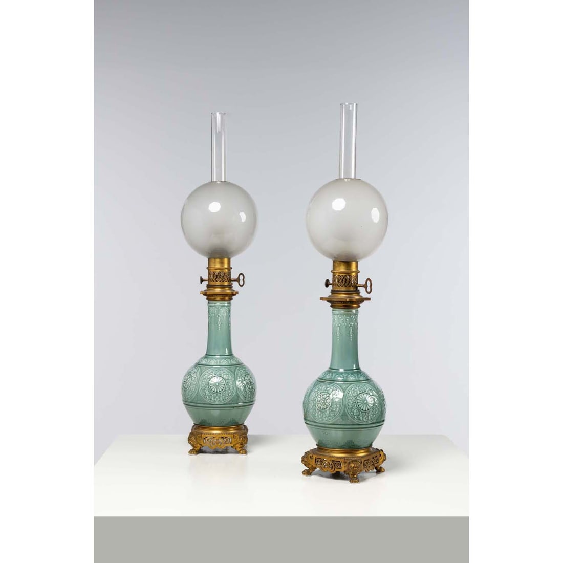 Theodore DECK (1823-1891) Pair of long-necked vases forming kerosene lamps in celadon enamelled: Theodore DECK (1823-1891)Pair of long-necked vases forming kerosene lamps in celadon enamelled ceramic decorated with rosettes and foliage, gilt bronze base openworked with foliage and lion's headsSig