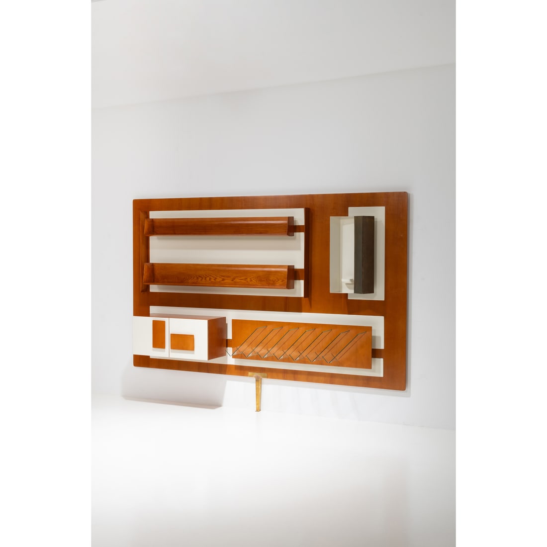 Gio Ponti (1891-1979) Lit wall-mounted bookshelf: Gio Ponti (1891-1979)Lit wall-mounted bookshelfOak wood, brass, lacquered metal, glass and lacquered woodEdited by Giordano ChiesaModel created circa 1955H 208 × L 296 × W 48 cmBibliography