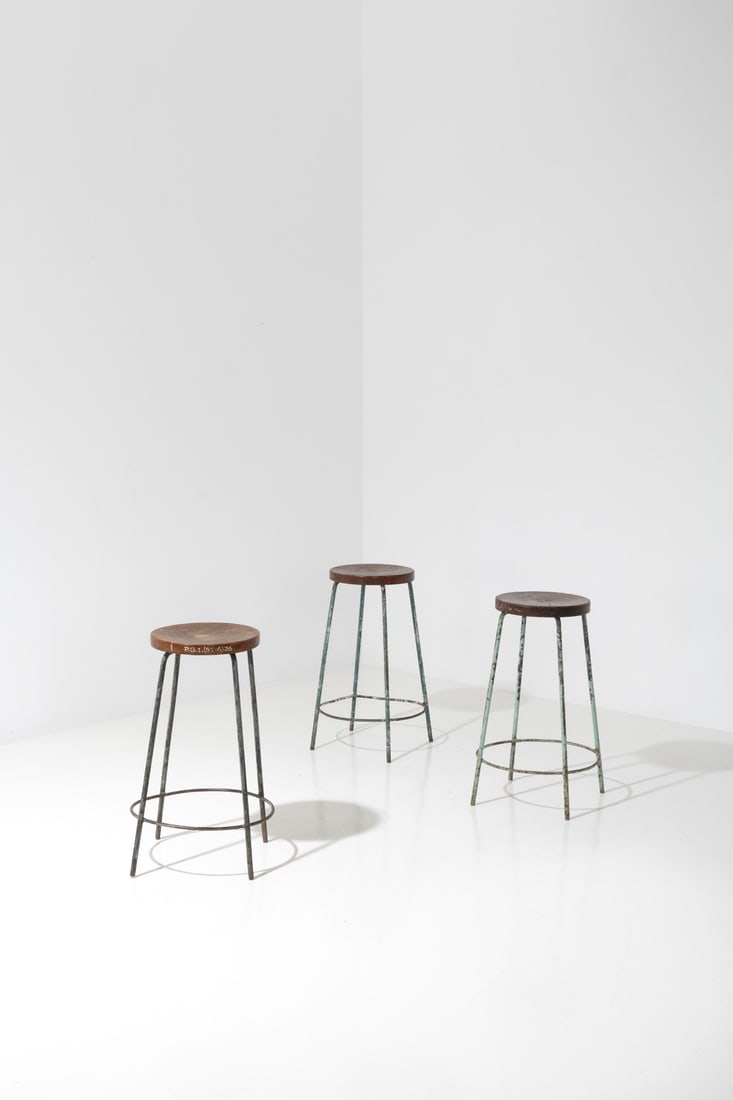 x Pierre Jeanneret (1896-1967) Set of three stools: x Pierre Jeanneret (1896-1967)Set of three stoolsTeak and lacquered metalPainted inventory no. 'P.G.I. (ST-6) 36' on oneModel created circa 1960H 70 × Ø 51 cmProvenance: Post Graduate Instit