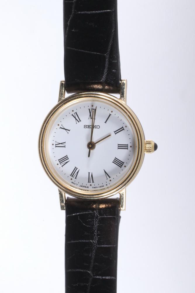 14K GOLD SEIKO WRISTWATCH: Lady's Seiko Wristwatch with 14K yellow gold round head and original black leather band, 7 1/2" long, 3/4" diameter head.
