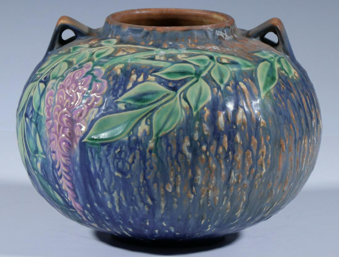 ROSEVILLE WISTERIA PATTERN VASE: Blue WIsteria Art Pottery Vase by Roseville, double handles and bulbous form, with original foil Roseville Pottery label on base, 7" high, 8 1/2" diam. Good condition.