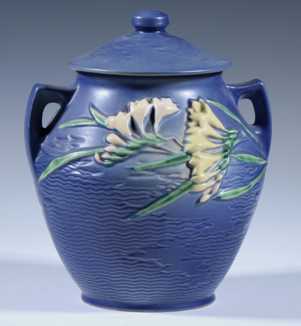 ROSEVILLE BLUE FREESIA COOKIE JAR: Blue Freesia Cookie Jar by Roseville Pottery, with lid, double handle design, raised 'Roseville USA, 4-8"' mark on base, 10 1/2" high, 8" diam. Good condition.