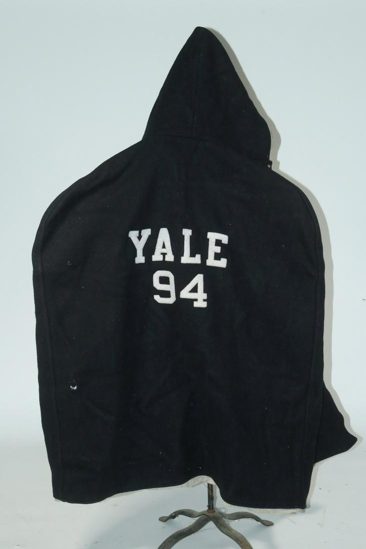 YALE FOOTBALL 1940S SIDELINE CAPE FOR NUMBER 94: Heavy Black Wool Cape with white cotton twill lining, snap closure, 'YALE 94' applied on back, having small patch hand pockets, with hood. Very good condition, no moth damage.