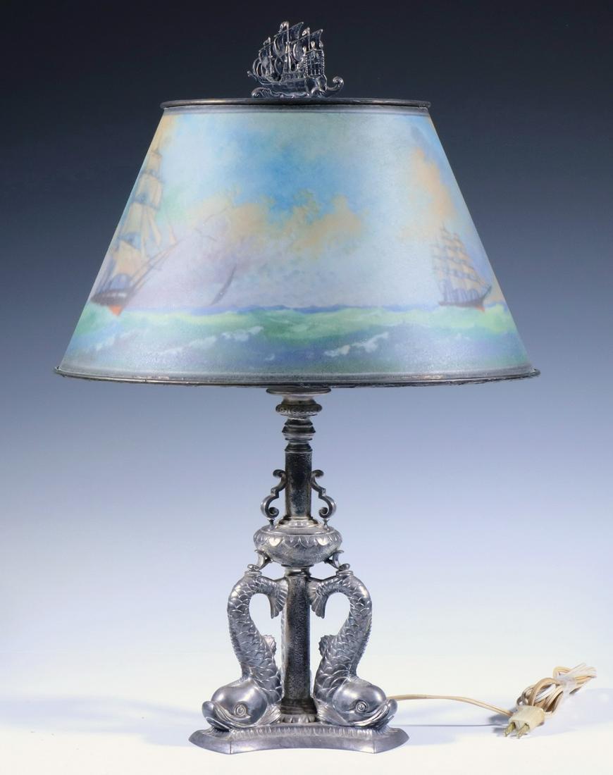 PAIRPONT TABLE LAMP WITH MARITIME THEME: Silver-plate Lamp Base consisting of three Renaissance style Dolphins, supporting a tapered ribbed glass shade back-painted with a scene of four sailing ships on the open sea, topped by a sailing ship