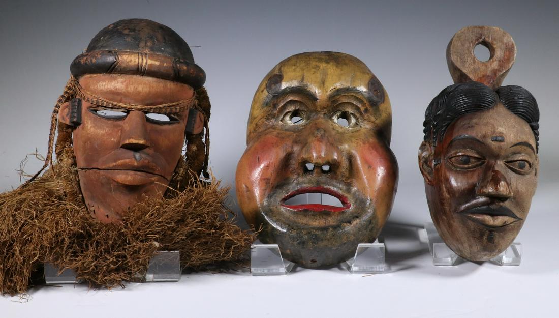 (3) CARVED WOODEN MASKS WITH LUCITE STANDS: Including: African Igbo Dance Mask, early 20th c., Ivory Coast, carved and painted wood with hinged mouth, raffia trim, 9" tall, good condition; PLUS Inuit Mask of a Grimacing Man, in carved and paint