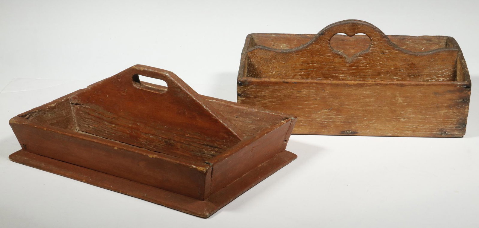 (2) 19TH C. KNIFE BOXES: Lot of (2) Early Wooden Cutlery Trays, incl: Red painted box with cut-out handle, set on a beveled edge base, 4 3/4" high, 12" x 8", corner separation; and Nailed box with heart cut-out handle, 5 1/4"