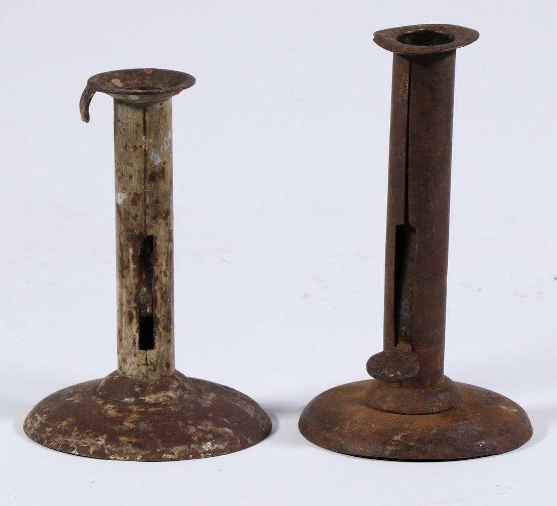 (2) 19TH C. TIN HOGSCRAPER CANDLEHOLDERS: Pushup Candlesticks with typical round domed bases, integral drip stops, thumb tab sliders (one missing), remnants of paint, 5 3/4" & 6 1/2" tall. Rusted.