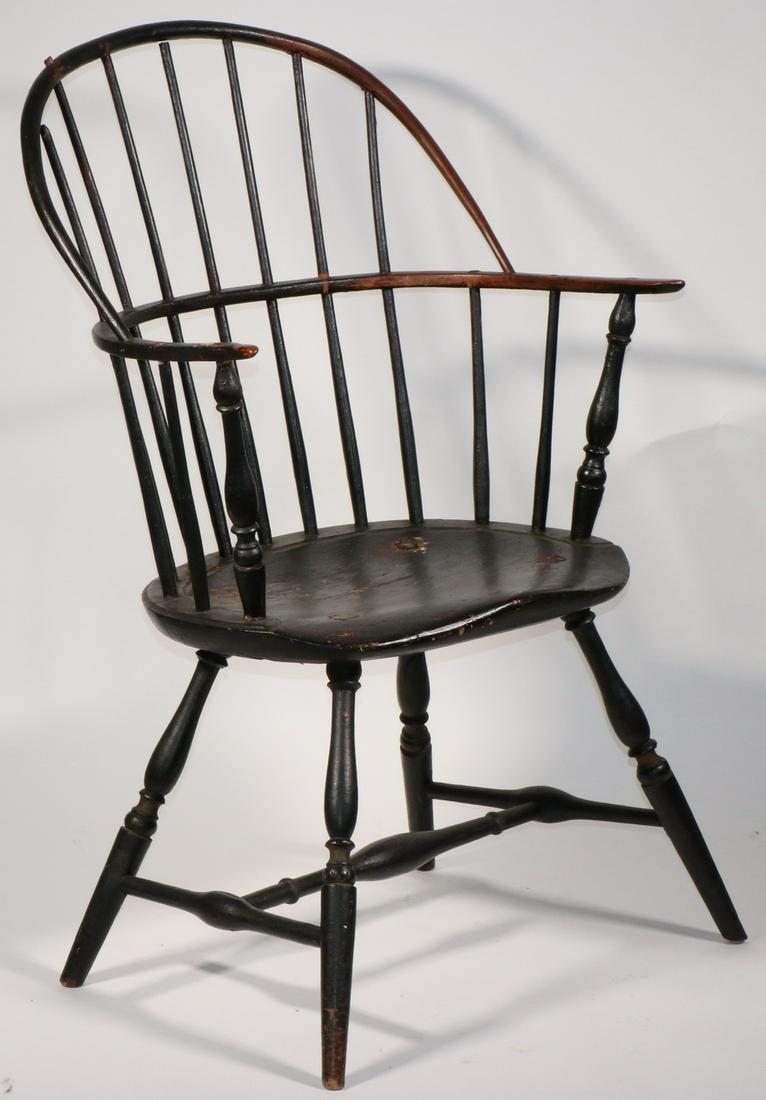 19TH C. BLACK PAINTED SACK BACK WINDSOR CHAIR: Classic form with seven spindle bentwood back, continuous arm, bodged broad but shallow seat with runnel, splayed ring and urn turned legs with boldly turned stretcher, 17" seat, 28" arms, 37" back, 2