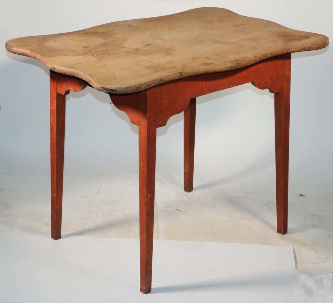 EARLY TAVERN TABLE: 18th c. Scrub Top Pine Tavern Table, with shaped overhanging top, red painted base with shaped apron, set on square tapered legs, 27 1/2" high, 37 1/4" x 24". Shrinkage cracks, surface wear.