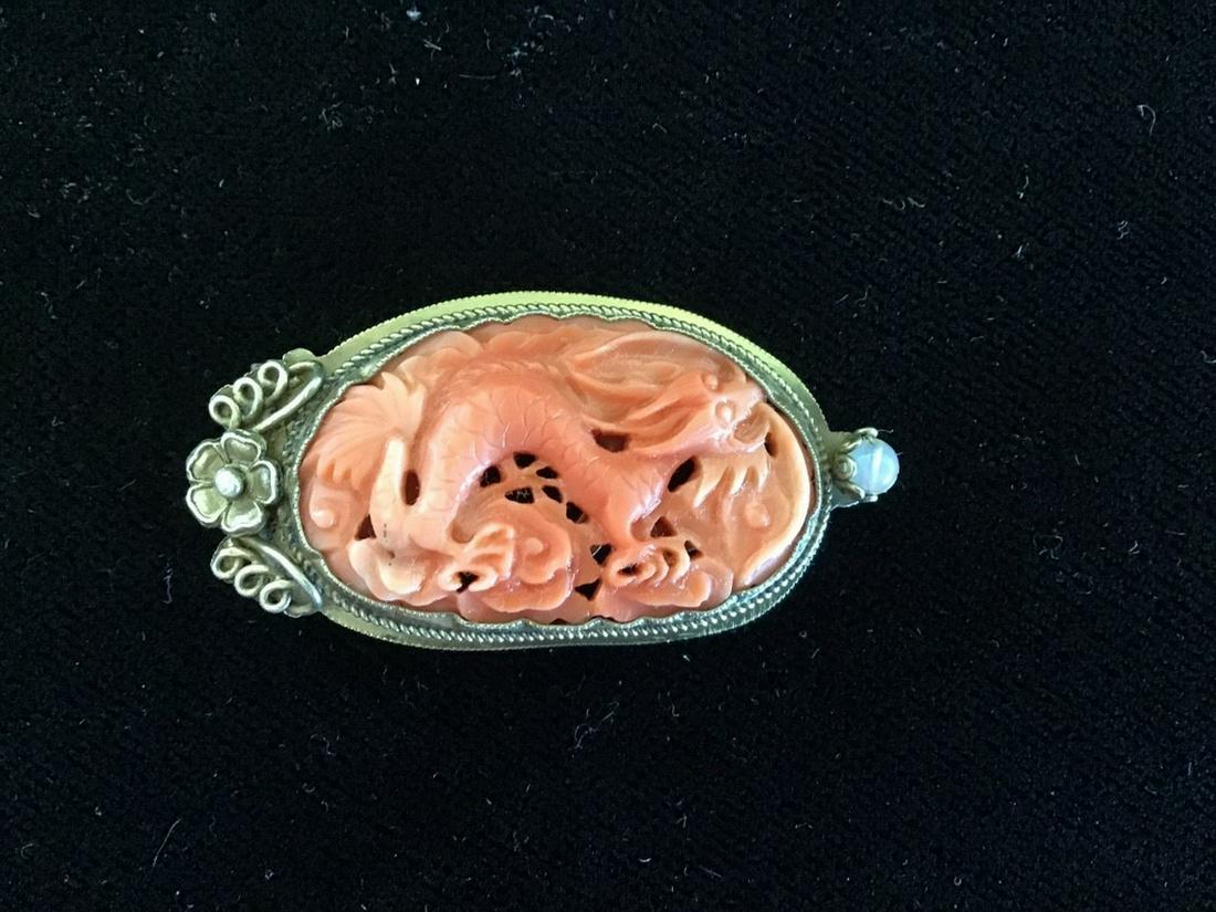 CORAL CLIP: Vintage Chinese Gilt Silver Sweater Clip, with an oval carved coral dragon in center, circa 1920/30s, 1" high, 1 7/8" wide. Very good condition.