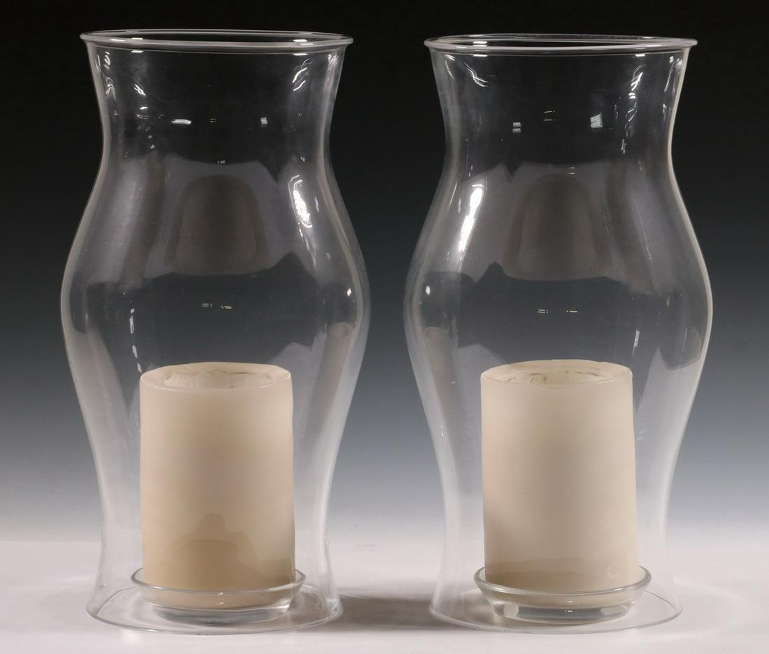 PR RALPH LAUREN HURRICANE SHADES & CANDLEHOLDERS: Pair of Contemporary Clear Glass Hurricane Shades, with glass candle trays and white pillar candles, all with Ralph Lauren acid etched mark, 14 3/4" high, trays: 4 1/2" diam. Base edge chip to one sha