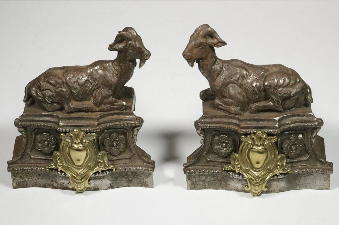 PR OF SMALL FRENCH FIREPLACE CHENETS: Baroque Pedestal with a Recumbent Goat on each, having opposing stances, in nickel plated steel with a gilt medallion on the front of each, 7 14" x 6 1/2" x 2 3/4". Light corrosion.