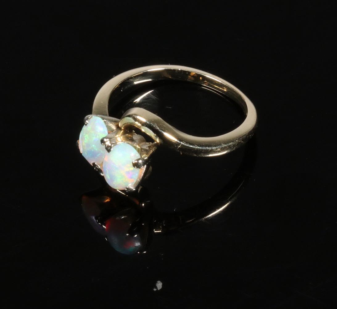 LADIES GOLD RING WITH OPALS: 14k yellow gold ring set with 2 oval Austrailian opals. One opal chipped on outer edge. 1.7 dwt. Size 4-1/2.