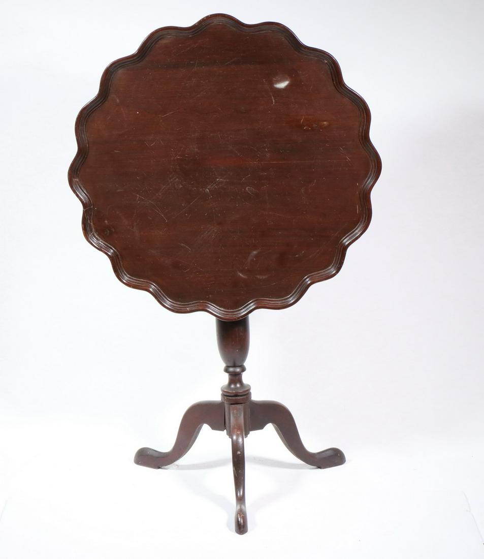 TILT TOP MAHOGANY TEA TABLE: Late 19th c., with molded scalloped edge top, ring and urn turned post, arched leg tripod base ending in snake feet, 28 1/2" x 25 1/2" diam, 20" leg to leg. Loose trim.