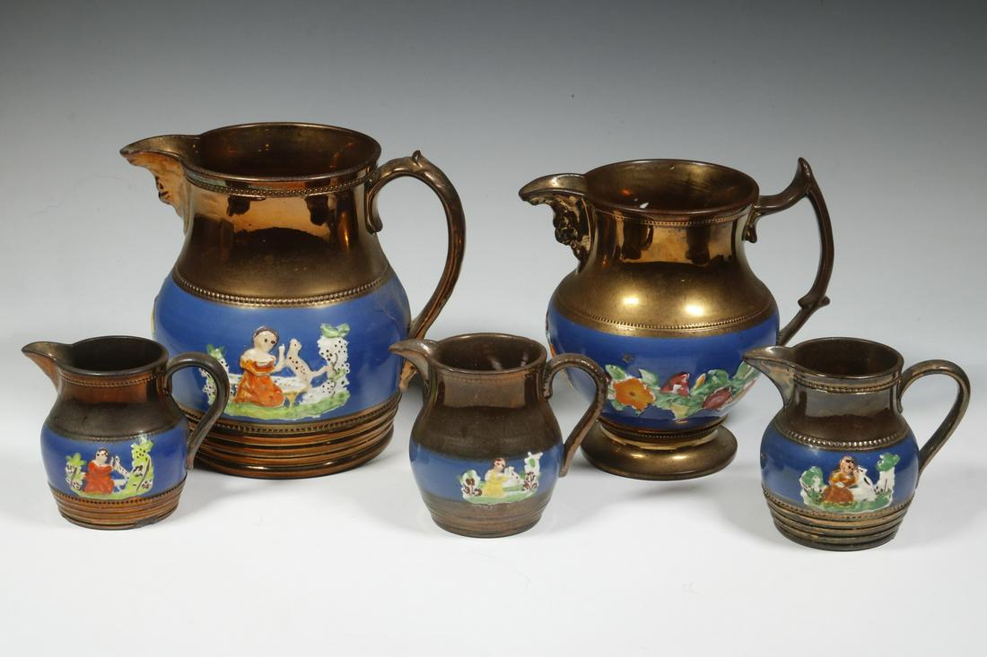 (5) COPPER LUSTREWARE JUGS: Group of (5) 19th c. Staffordshire Relief Molded Lustre Jugs, with blue glazed bands, most with raised figural decoration, one with floral motifs, 3 1/4" to 6 1/2" high. Most with minor paint losses,