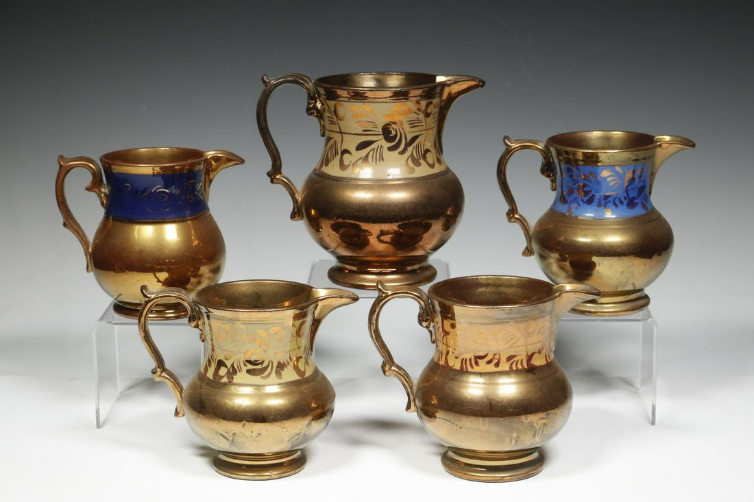 (5) COPPER LUSTREWARE JUGS: Group of (5) English Victorian Copper Lustre Jugs, with painted foliate decoration, 4 1/2" to 5 5/8" high. One with small spout chip.
