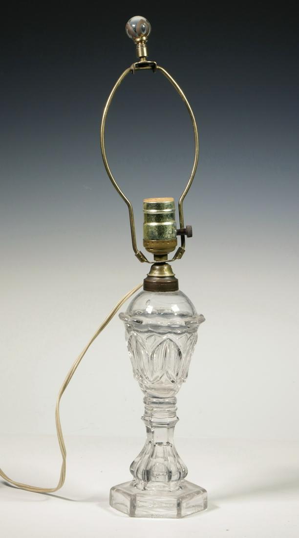 GLASS WHALE OIL LAMP AS TABLE LAMP: Early 19th c. Flint Pattern Glass Whale Oil Lamp, with hexagonal base, fitted as a table lamp (not drilled), single socket fixture with harp and clear glass finial (no shade), 19 3/4" high. Base edge 