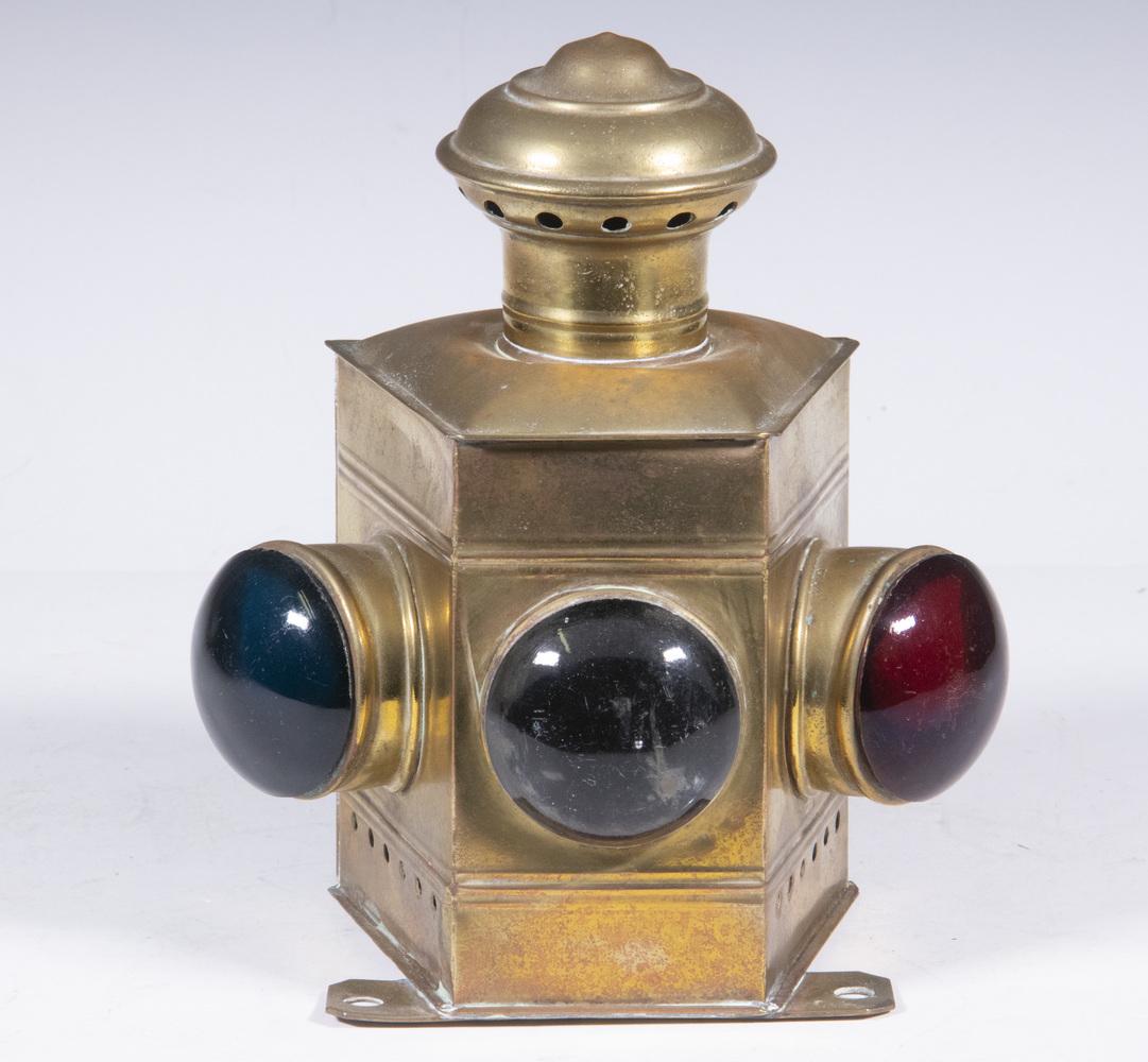 SMALL BRASS PORT & STARBOARD LAMP: Whale Oil Skiff Sized Prow Light, having solid glass bullseye lenses in red, clear and green, folding handles, mounting bracket. Burner intact. 8 3/4' x 7" x 4 1/2", exterior polished. Scarce form.