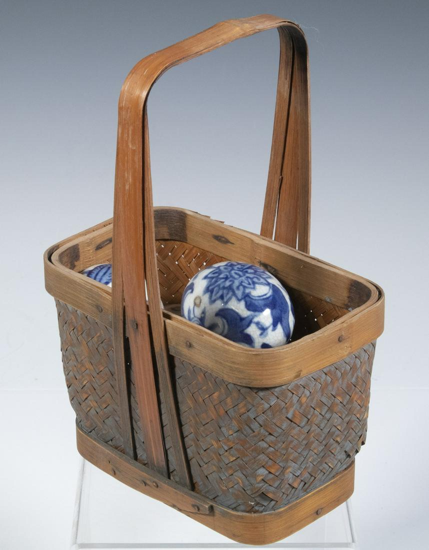 BLUE & WHITE CERAMIC EGGS IN A BASKET: Lot of (5) Chinese Glazed Pottery Eggs, with a variety of leaf and floral decorative motifs, craquelure surface, 2 1/4" x 1 7/8", unglazed areas; in a Chinese fixed handle basket, 8 1/4" high, 6" x 4"