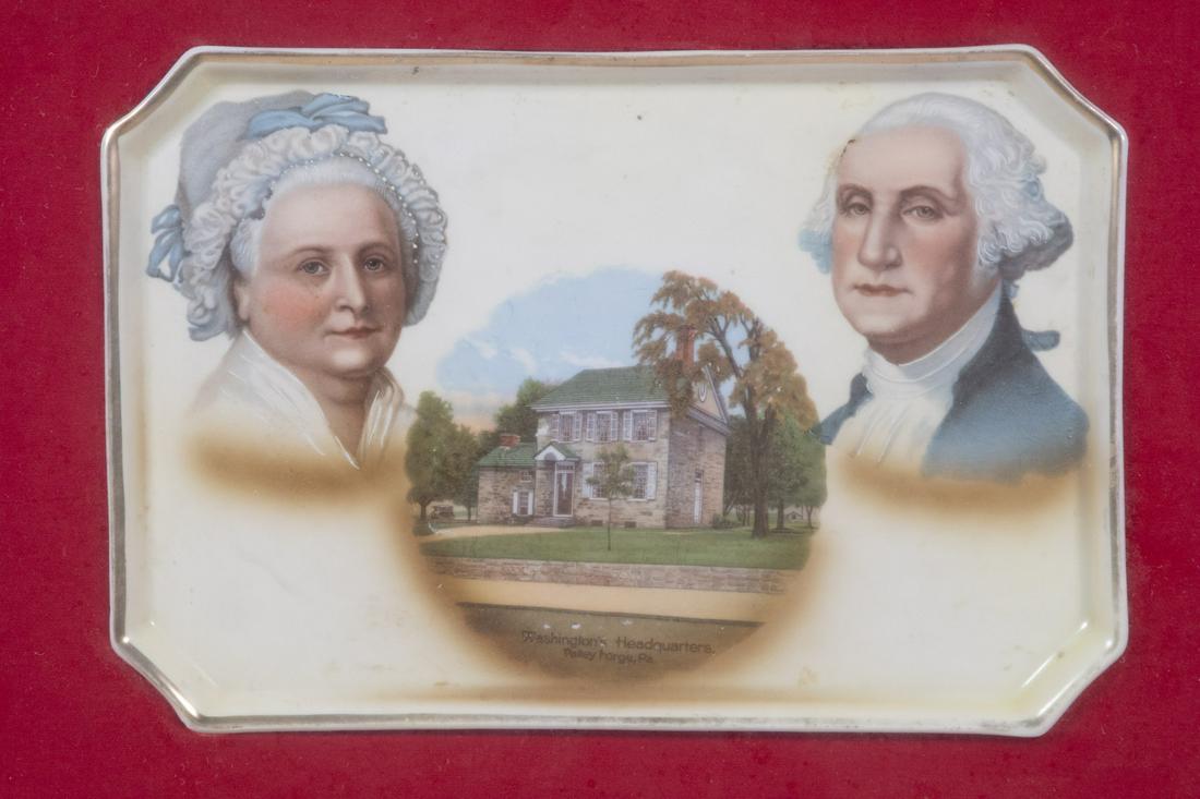 FRAMED COMMEMORATIVE PORCELAIN TRAY OF GEORGE & MARTHA WASHINGTON AT VALLEY FORGE: George & Martha Washington Valley Forge Collector Plate Made in Germany transferware for A.C. Bosselman & Co. New York, circa 1900. Gold edged, 7 1/4" x 10" elongated rectangular tray, set into a red