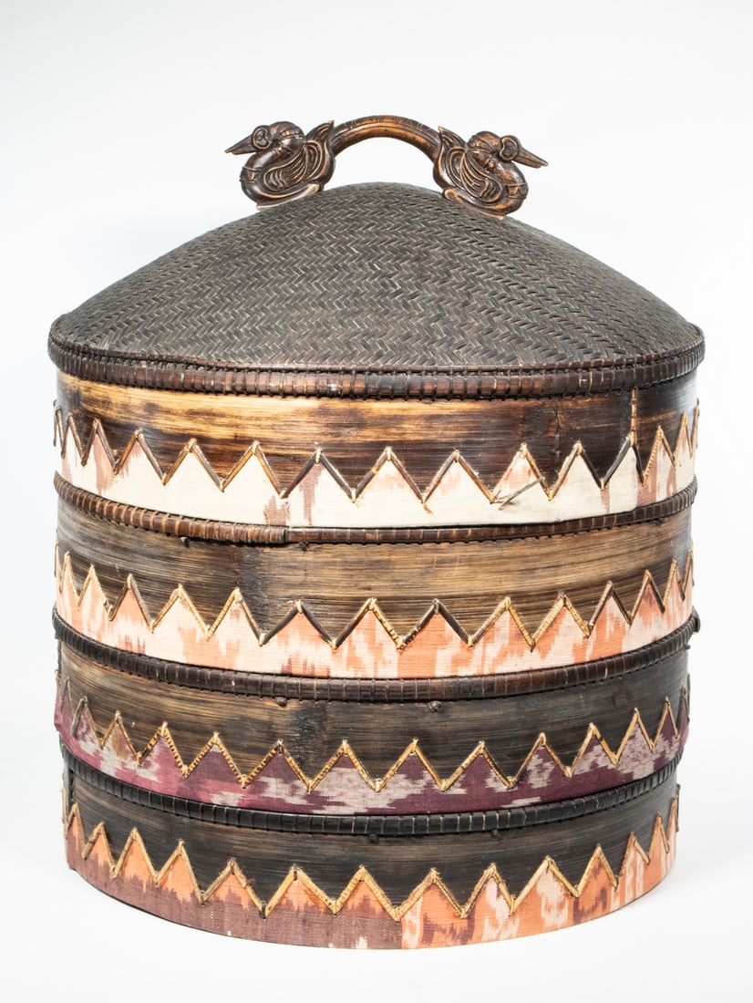 LARGE CHINESE WOVEN REED CARRYING CONTAINER: Cylindrical Storage Basket having a herringbone woven reed domed top set with a carved wooden dragon form handle, the sides in bark with sawtooth cloth decoration, friction fit separation is at the to