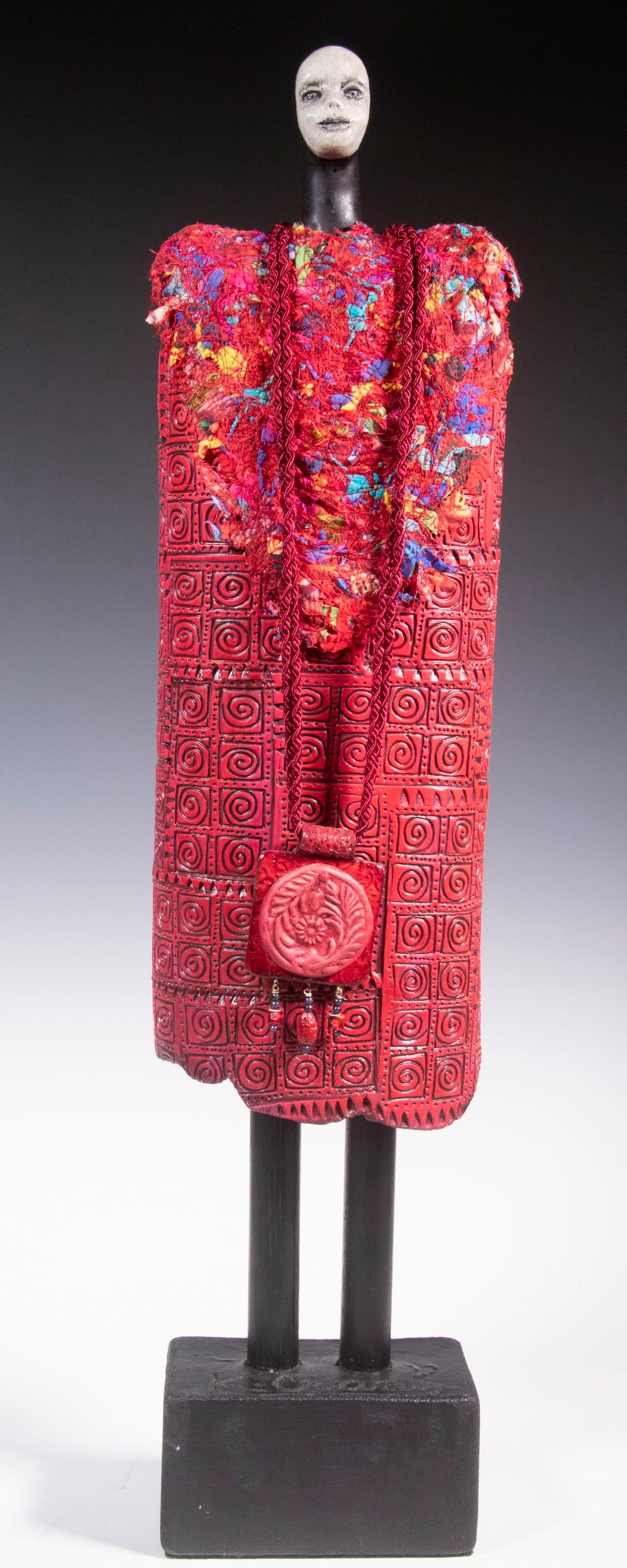 CONTEMPORARY PORCELAIN FIGURE SIGNED 'K. OCARIN': Sentinel Figure of a Woman, represented by a bright and patterned porcelain dress hung on a carved and painted wood figure, with cloth shawl and necklace, signed on base. 28 1/2" tall.