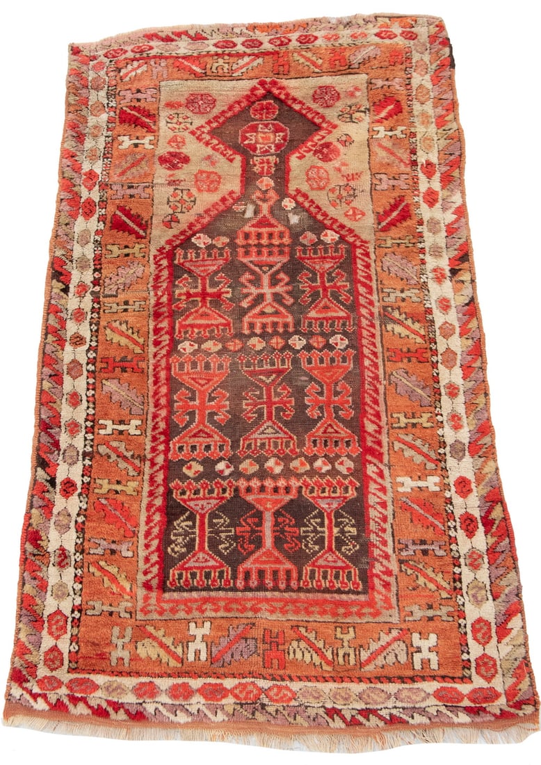 ANATOLIAN PRAYER RUG (2' 10" x 5'): Features three columns of candelabra flanked by octagons in light red, dark red, ivory and aubergine on the aubergine field with a pumpkin serrated leaf border. Several holes throughout and aubergine