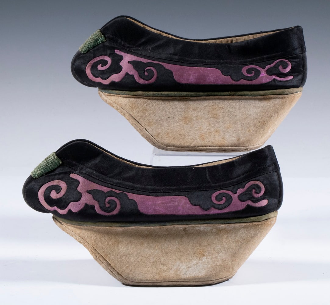 PAIR OF CHINESE QING MANCHU NOBLEWOMAN'S SHOES: Late Qing Chinese Ladies Manchu Platform Shoes, or Maitixie, in black with lavender wave decoration, raised on sheepskin wrapped shaped block heels, 10" long.