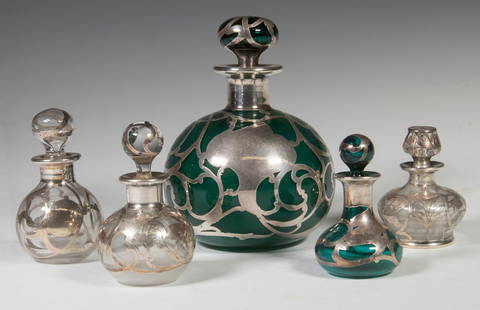 (5) ART NOUVEAU SILVER OVERLAY DRESSER BOTTLES: Group of (5) Early 20th Stoppered Vanity Bottles, with fancy sterling silver overlay, three clear glass and two emerald green glass, largest is by Scharling & Co. (Newark, NJ, 1892-1950), clear bottle