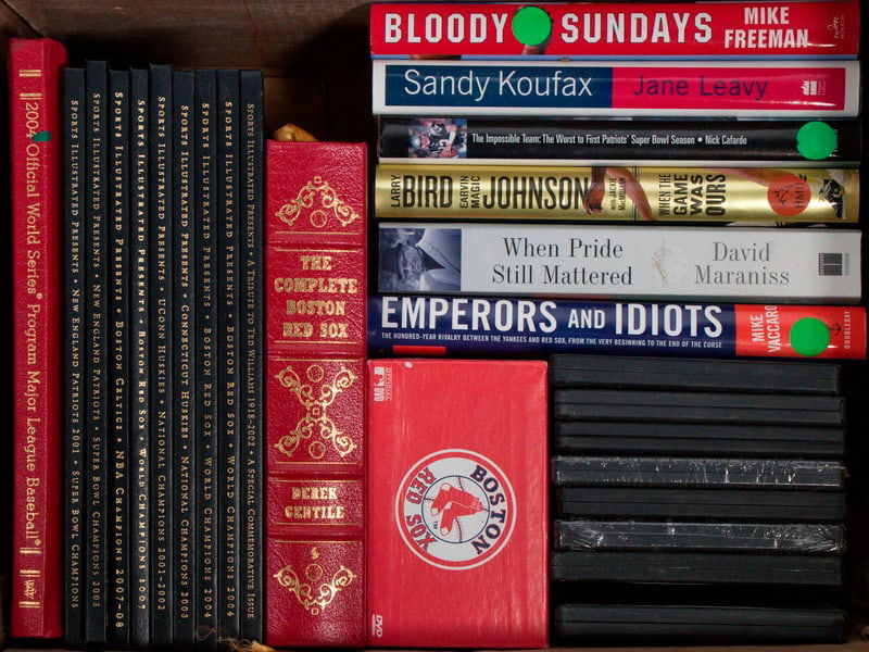 (26) COLLECTABLE SPORTS BOOKS & DVDS: Including: 2004 Red Sox vs Cardinals hardbound Official World Series Program; (9) Hardbound Ltd Ed Sports Illustrated: Patriots 2001 Champs, Patriots 2003 Champs, Celtics 2008 Champs; Red Sox 2007 Cha