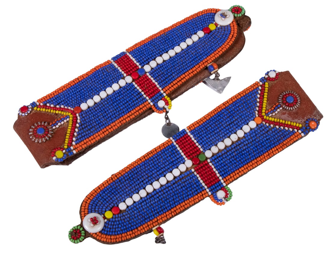 PR MAASAI BEADED EAR FLAPS: PR MAASAI BEADED EAR FLAPSPair of East African Traditional Ear Pieces, worn by married women, consisting of beadwork sewn on to leather backing, 7 1/2" x 2 1/2". Surface wear.
