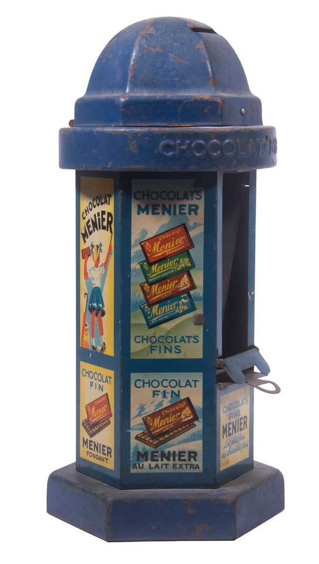 MENIER FRENCH CHOCOLATE DISPENSER: MENIER FRENCH CHOCOLATE DISPENSER Circa 1930s Tin Dispenser, in the form of a kiosk with Menier Chocolate brand advertising. Coin slot at top, top band embossed "Chocolat Menier." 10 1/2 x 5 x 5 in.