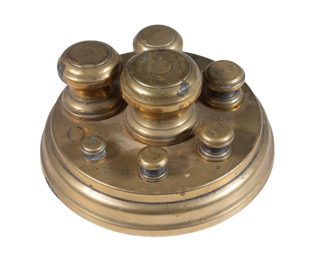 BRASS "IMPERIAL STANDARD" WEIGHT SET IN HOLDER: BRASS "IMPERIAL STANDARD" WEIGHT SET IN HOLDER (7) Piece Set of English Brass Weights, 1/4-oz up to 1-lb, in a round fitted brass stand. OS: 2 1/2 x 4 1/2 x 4 1/2 in. (6.4 x 11.4 x 11.4 cm.)