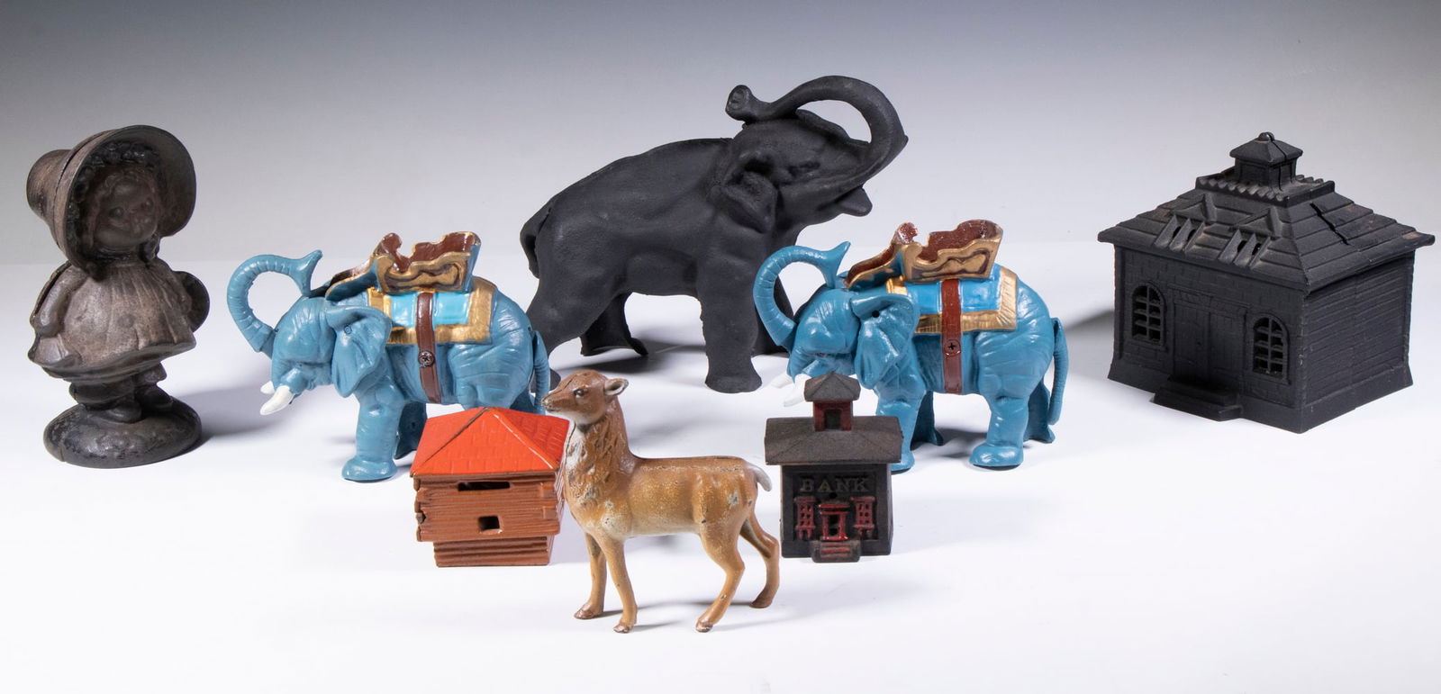 (8) CAST IRON STILL BANKS: (8) CAST IRON STILL BANKS Collection of (9) Replica Penny Banks, incl: (2) Elephants with howdahs, 5" high; Standing deer, 5" high; Large black elephant, 7" high; Large building with cupola, 5 1/2"