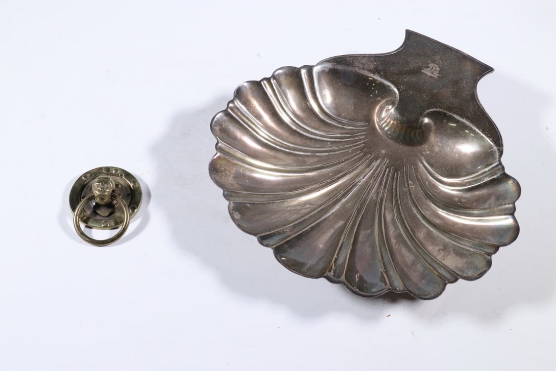 (2) VINTAGE METAL ACCESSORIES: (2) VINTAGE METAL ACCESSORIES Lot of (2) Metal Decorative Pieces, incl: Late 19th c. brass figural drop ring drawer pull in the form of a monkey head; and Silver plated copper scallop shell serving