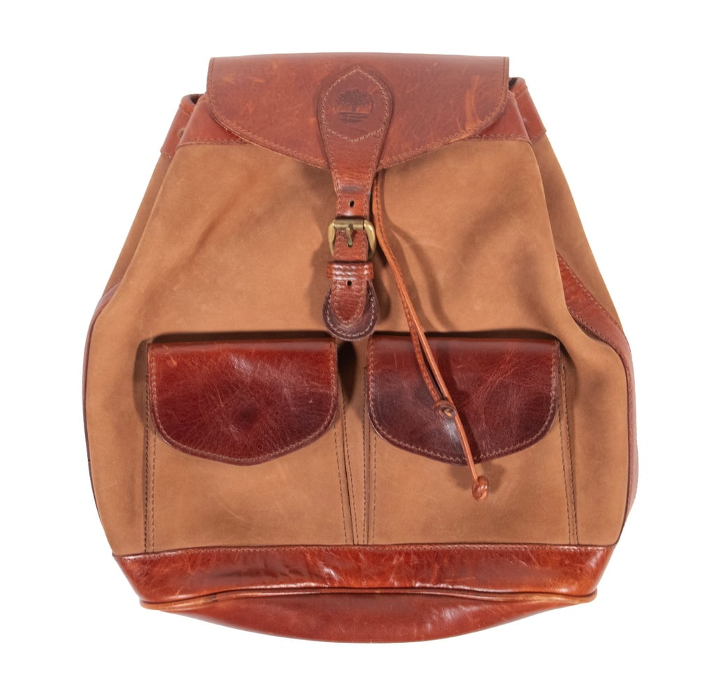 VINTAGE TIMBERLAND LEATHER AND SUEDE BUCKET BACKPACK, MADE IN USA: VINTAGE TIMBERLAND LEATHER AND SUEDE BUCKET BACKPACK, MADE IN USA A vintage Timberland bucket-style backpack crafted in smooth brown leather with suede panels, featuring two front flap pockets, solid